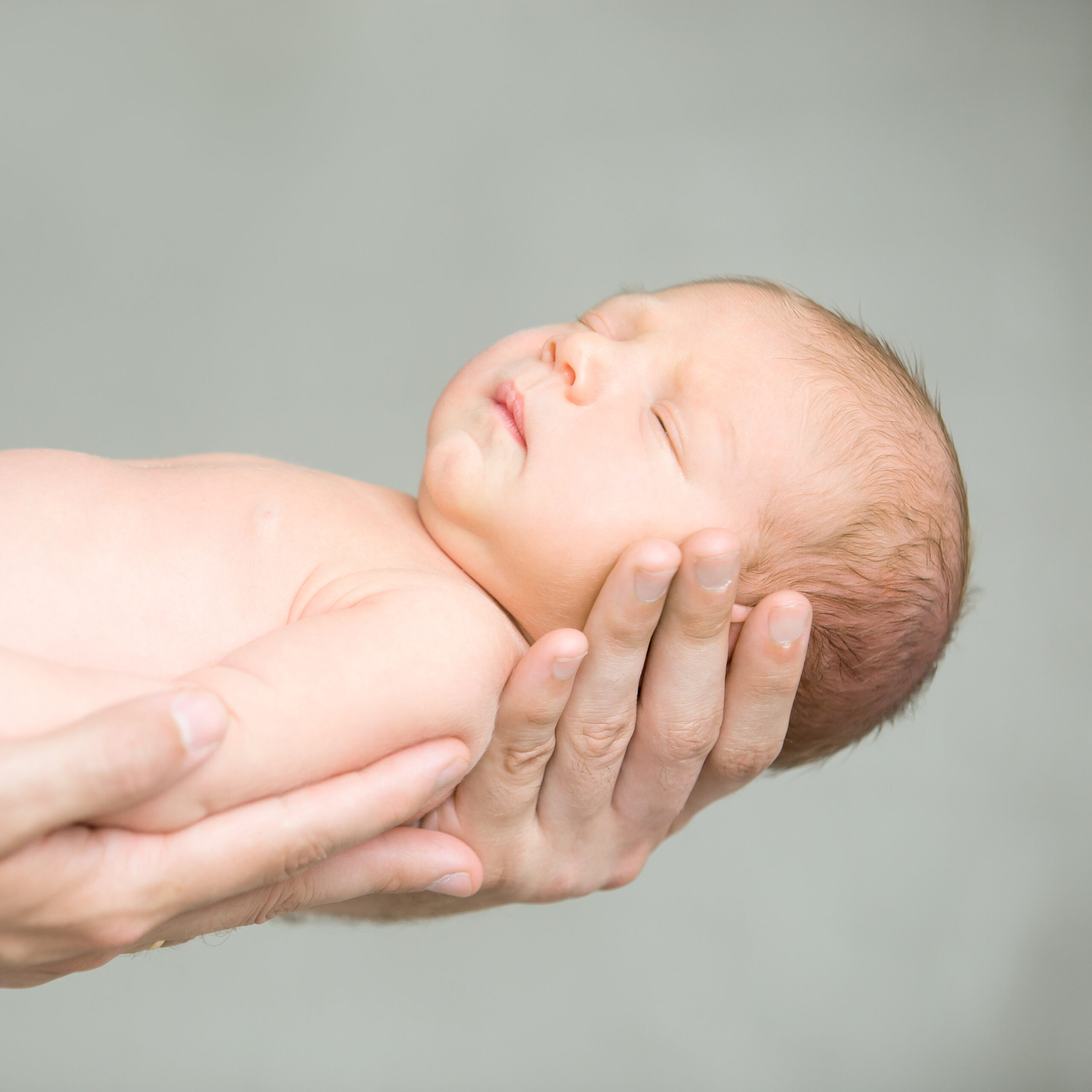 portrait sleeping newborn hold hands scaled